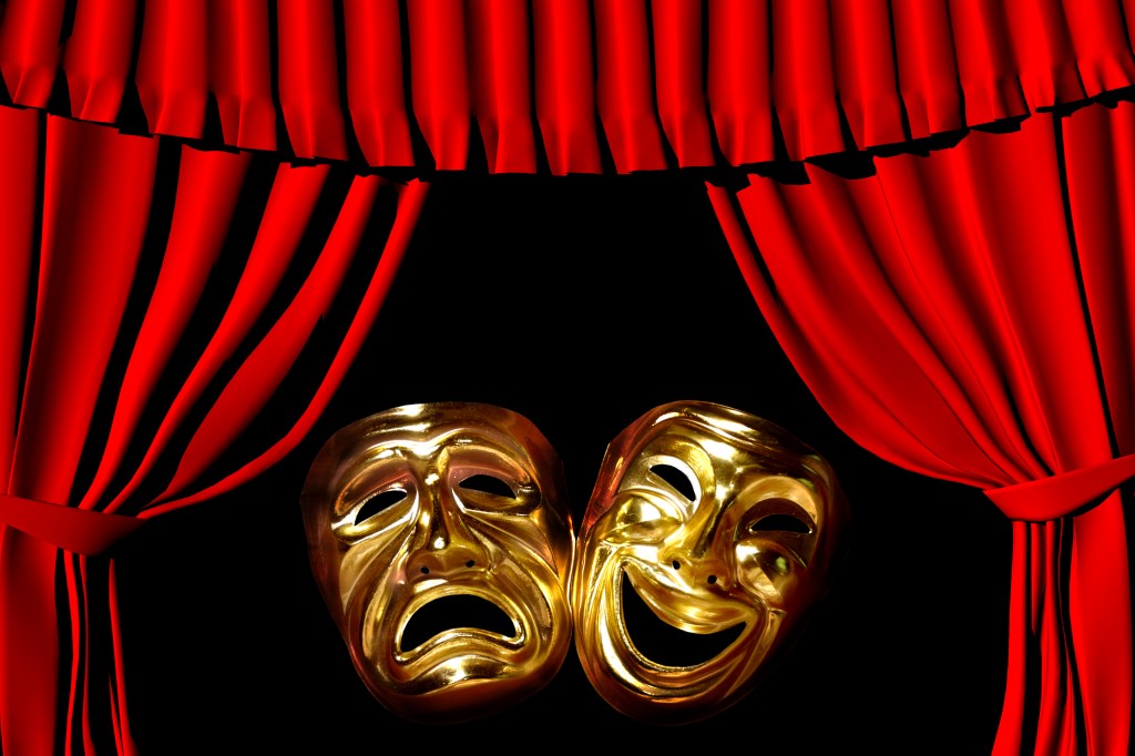 gold mask of tragedy and comedy between a red theatre curtain