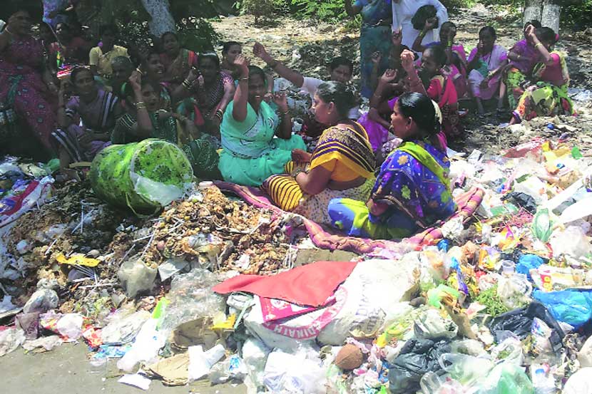 पोलीस बंदोबस्तात कचरा उचलण्यास आलेल्या अधिकाऱ्यांना महिला कामगारांनी कचऱ्याच्या ढिगावर बसून जोरदार विरोध केला.