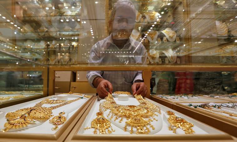 A salesman arranges a gold necklace in a display case inside a jewellery showroom on the occasion of Akshaya Tritiya, a major gold buying festival, in Kolkata, India, May 9, 2016. REUTERS/Rupak De Chowdhuri