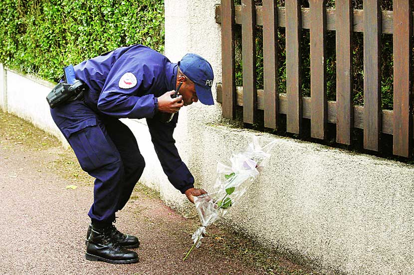फ्रान्समधील मॅगननव्हिले येथील हल्ल्यात मृत्युमुखी पडलेल्या आपल्या सहकाऱ्यांना श्रद्धांजली वाहताना पोलिस कर्मचारी