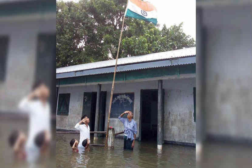 पूरपरिस्थितीत ध्वजारोहण साजरे करणारे शिक्षक आणि विद्यार्थी 