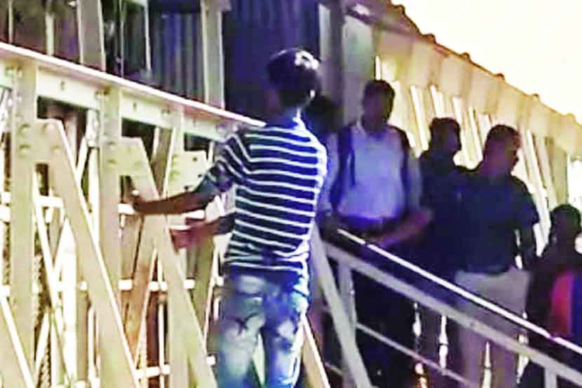रेल्वे पुलावर चढून आत्महत्या करण्याचा प्रयत्न करत असलेला तरुण.