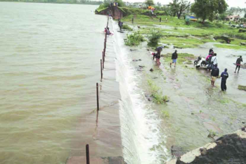 कोल्हापुरातील कळंबा तलाव भरल्याने सांडव्यावरून पाणी ओसंडून वाहत असून येथे लोकांची गर्दी वाढत आहे.      (छाया — राज मकानदार)