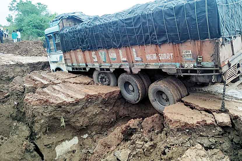 रस्ता वाहून गेल्याने चिखलात रुतलेला ट्रक.