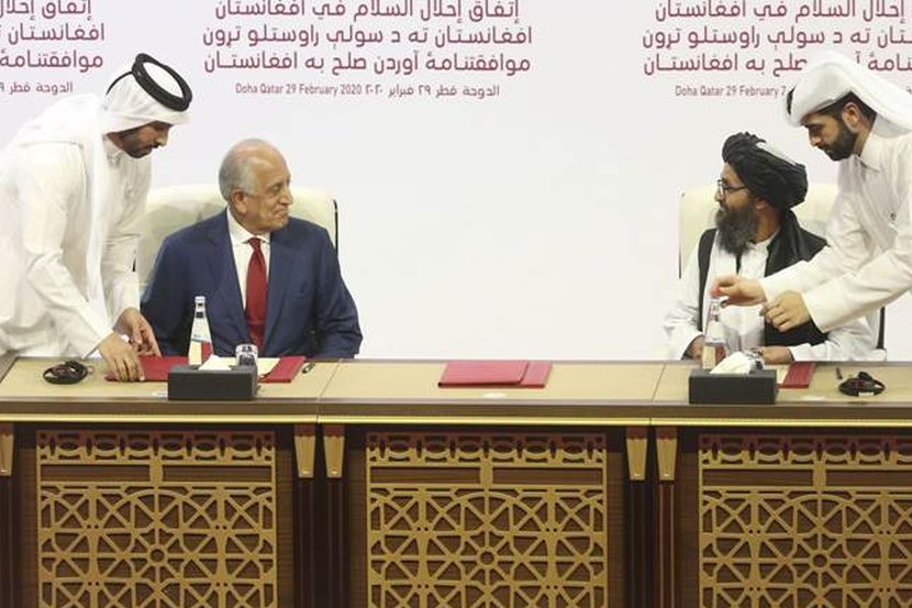 U.S. peace envoy Zalmay Khalilzad, left, and Mullah Abdul Ghani Baradar, the Taliban group's top political leader sign a peace agreement between Taliban and U.S. officials in Doha, Qatar, Saturday, Feb. 29, 2020. The United States is poised to sign a peace agreement with Taliban militants on Saturday aimed at bringing an end to 18 years of bloodshed in Afghanistan and allowing U.S. troops to return home from America's longest war. (AP Photo/Hussein Sayed)