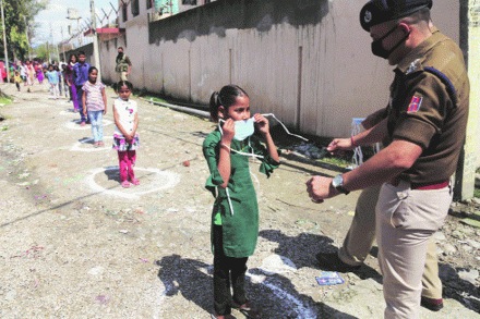जम्मूमधील स्थलांतरित मजुरांच्या मुलांना शनिवारी सुरक्षा दलाच्या जवानांनी मास्कचे वाटप केले.