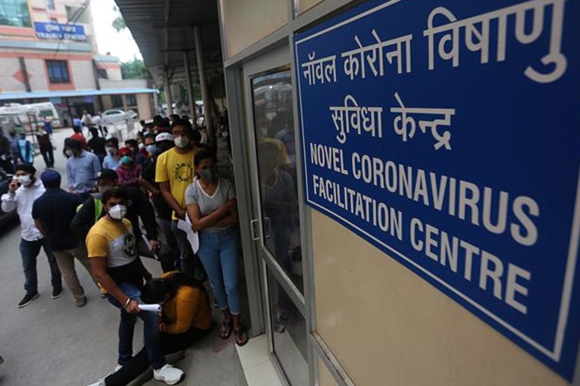 People with symptoms queue outside a coronavirus facilitation centre at the RML hospital in New Delhi. (Express photo by Tashi Tobgyal)
