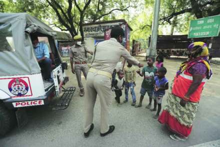 प्रयागराज येथे टाळेबंदीत अडकलेल्या मजुरांच्या मुलांना चहा-बिस्किटे देताना पोलीस कर्मचारी.