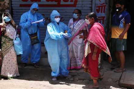 मुंबईत करोना बाधित क्षेत्रात आरोग्य अधिकारी नागरिकांची तपासणी करताना (छायाचित्र - निर्मल हरिंद्रन)