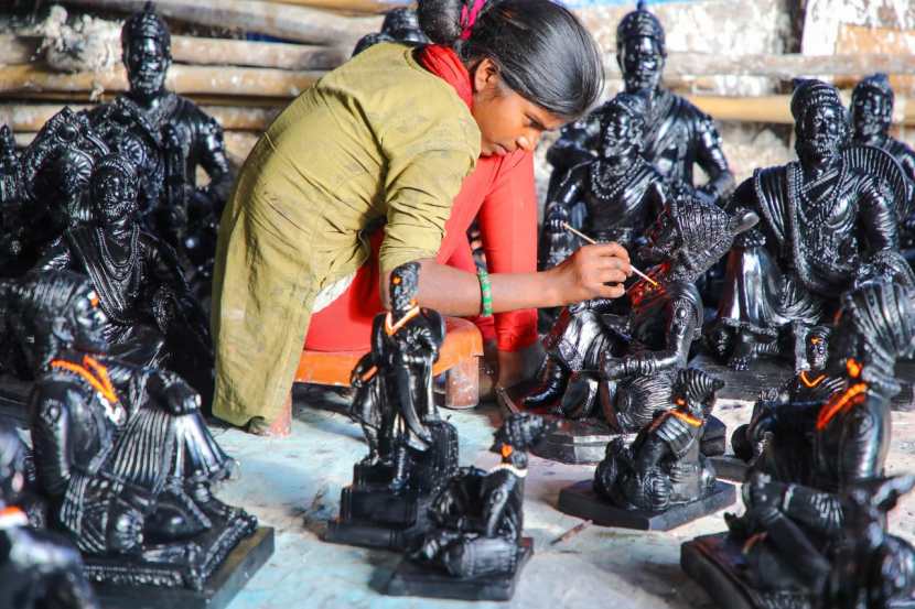 शिवरायांच्या मूर्तीला सजवण्यात मग्न असलेले मूर्तीकार.