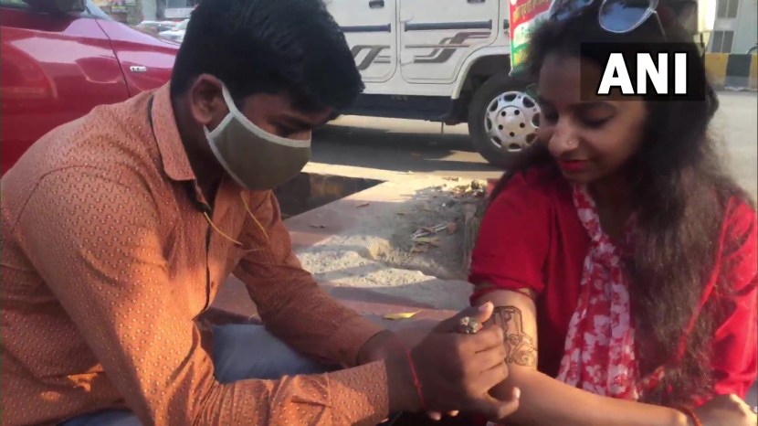 निवडणूक निकालानंतर प्रयागराजमधील काही महिला हातावर मेंहदीने बुलडोझर काढून घेत आहेत.