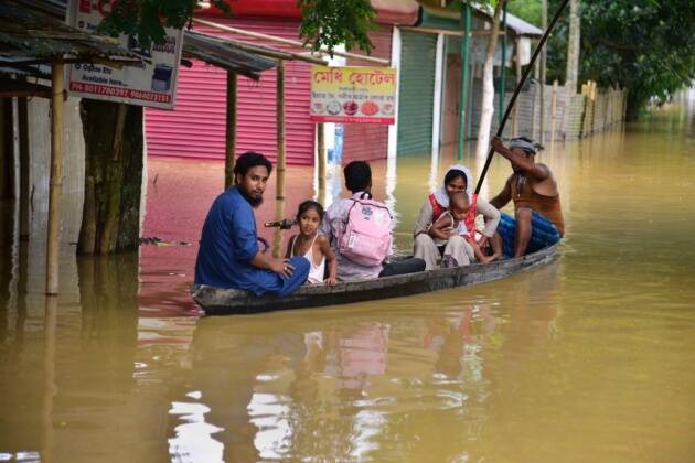 नागाव जिल्ह्यातील राहा गावात पूरग्रस्त ठिकाणी ये-जा करण्यासाठी गावकरी बोटीचा वापर करत आहेत.