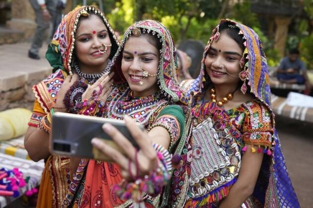 अहमदाबादमध्ये नवरात्रीच्या अगोदर, पारंपारिक नृत्य गरबाचा सराव करताना पारंपारिक पोशाख परिधान केलेल्या महिला सेल्फी घेताना. (AP)