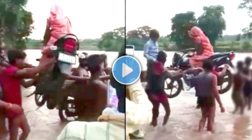 Video: आधी महिलेला बाईकवर बसवलं, मग बाईक खांद्यावर उचलून गावकऱ्यांनी पार केली नदी; बघा पुरातील हे भयानक दृश्य