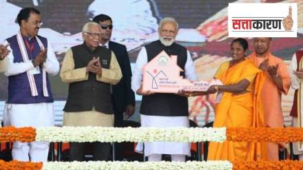 Prime Minister Narendra Modi hands over the key to a beneficiary of Pradhan Mantri Awas Yojana