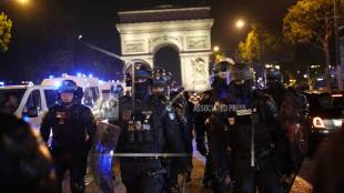 Police officers patrol in front of the Arc de Triomphe on the Champs Elysees in Paris