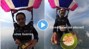 A man eats breakfast while paragliding high in the sky