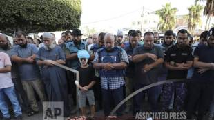 Al-Jazeera correspondent Wael Dahdouh, center, prays over the bodies of his wife, son, daughter, and grandson, killed in an Israeli airstrike in the south of the Gaza Strip