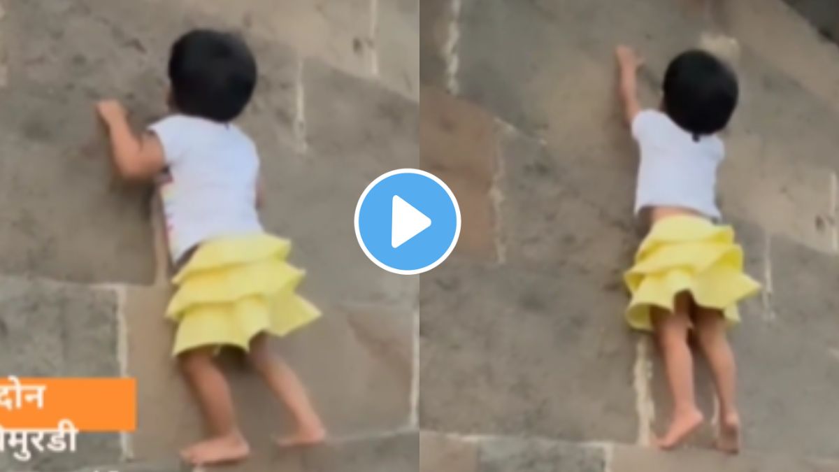 two year old girl climb on wall