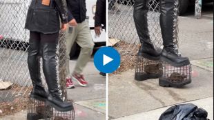 model wearing caged rat high heel on street