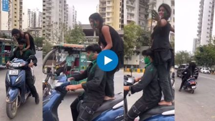 girl playing holi with boyfriend while standing on moving scooter