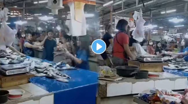 women beating each other with fish in fish market women fighting