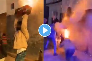 a man dancing with a box of fireworks on his head