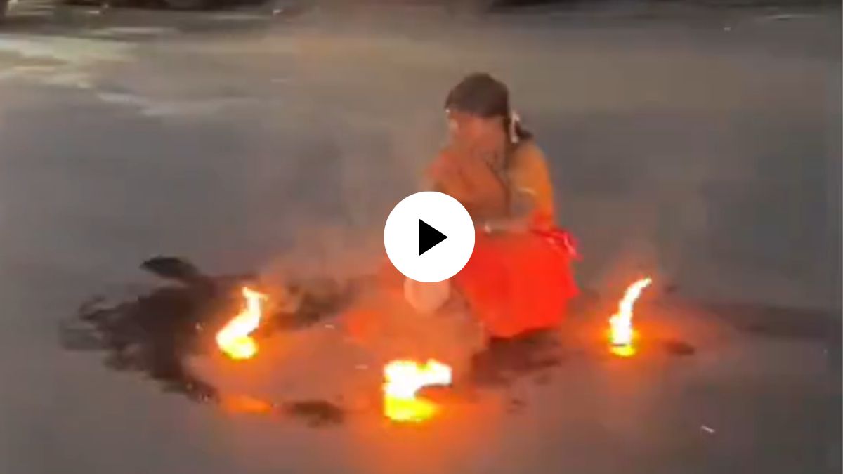 what is going on a woman sitting on middle of the road and doing weird things