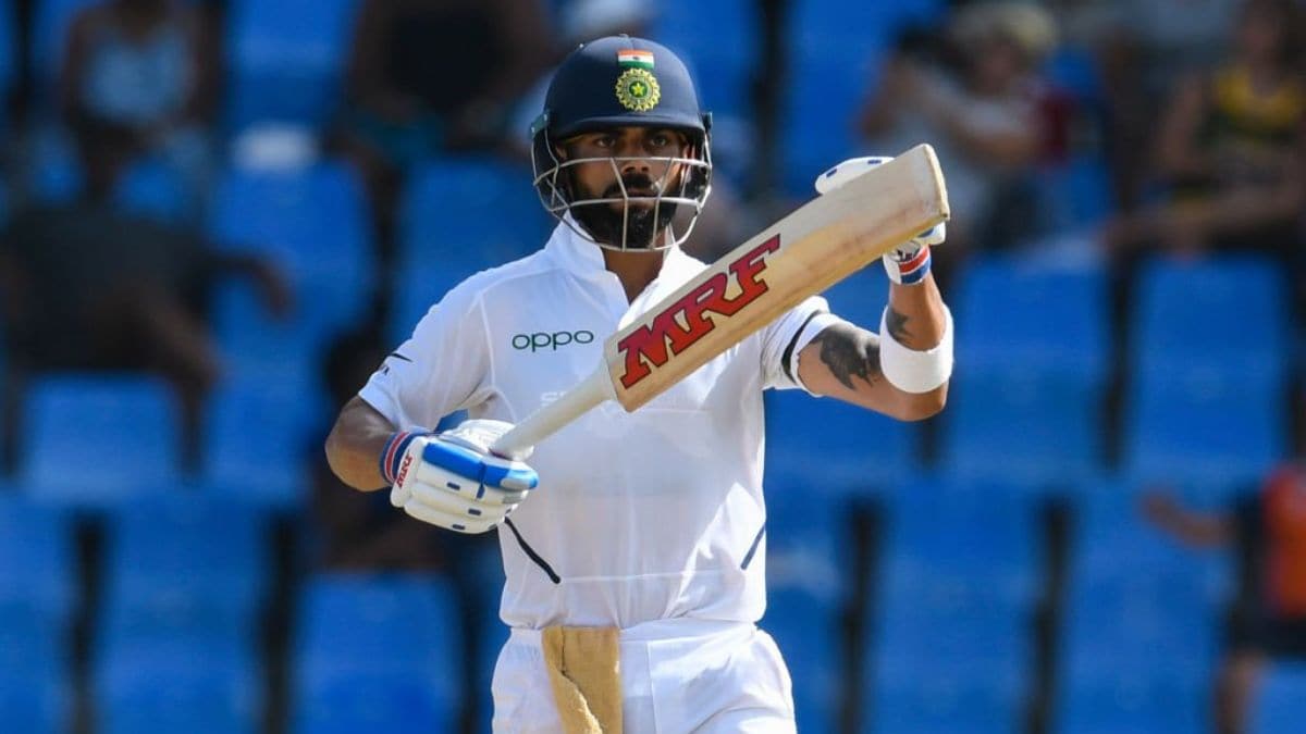 Virat Kohli celebrating a century during a Test match, amid discussions of retirement