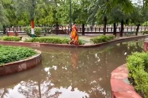गाझियाबादसारख्या एनसीआर भागातील उद्यानात पाणी साचल्यामुळे प्रभातफेरीसाठी आलेले लोक कठड्यावरून चालताना दिसले. (Image: IANS)