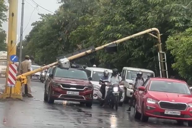 नोएडामधील एका सिग्नलमुळे एका खाजगी वाहनाचे मोठे नुकसान झाले आणि चालकाला दुखापत झाली कारण रेडलाईट वाकून कारच्या छताला नुकसान झाले. गाडीखाली अडकल्याने संपूर्ण रस्त्यावरील वाहतूक विस्कळीत झाली. (Photo: ANI)
