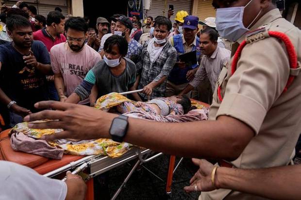 हैदराबादमध्ये इमारतीला आग लागल्यानंतर अग्निशमन दलाचे अधिकारी एका जखमी व्यक्तीला बाहेर काढताना. (Photo source: AP)