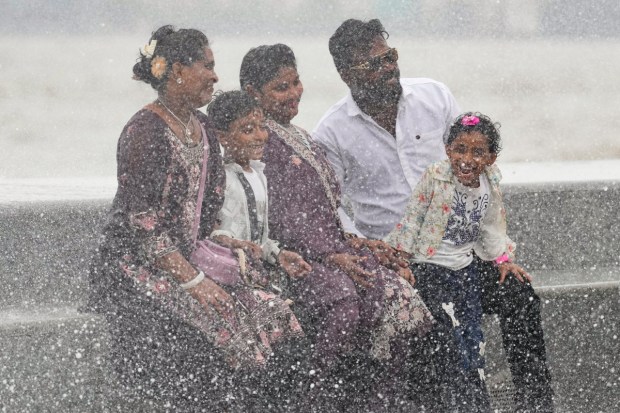 मुंबईत या पावसाळ्यातील सर्वात जास्त भरती-ओहोटीच्या वेळी मरीन ड्राइव्हवरील रस्त्यावर उंच लाटांच्या पाण्यात लोक भिजताना. (पीटीआय फोटो)